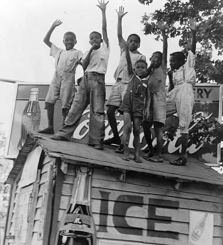 Children playing on top of Coca Cola stand, Little Rock, Arkansas  Photo: Dorothea Lange