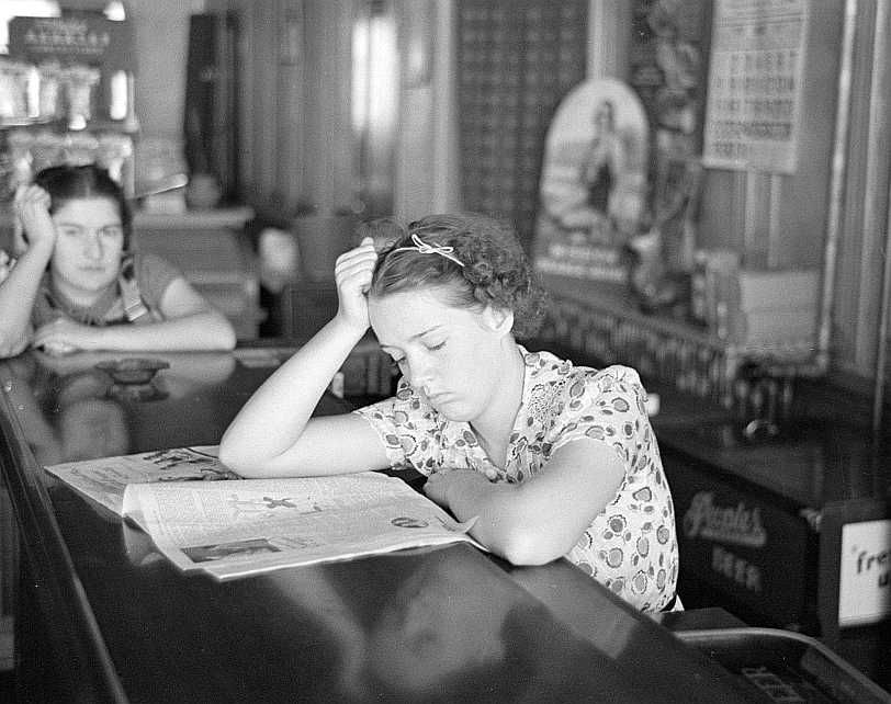 Girl reading newspaper in restaurant, Tower, Minnesota Photo: Lee Russell