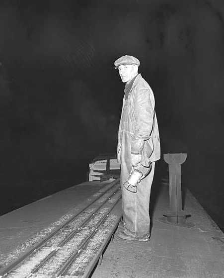 Brakeman atop caboose waiting to signal engineer on Indiana Harbor Belt Railroad between Chicago, Illinois and Hammond, Indiana Photo: Jack Delano
