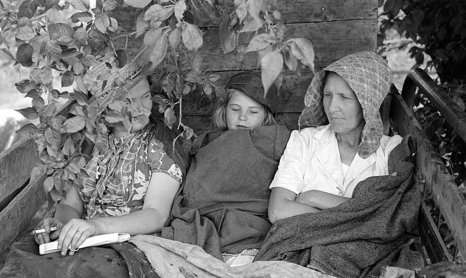 Migrant's car stopped along the road, with part of migrant family in rear seat of truck, under a tree to await the rain's passing, near Muskogee, Oklahoma                 Photo: Russell Lee