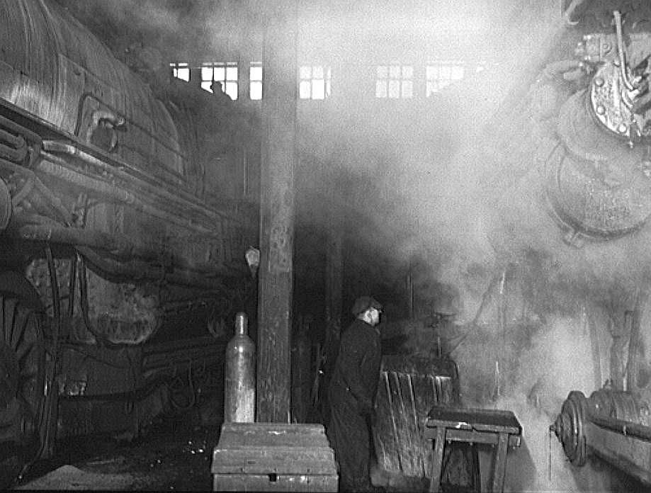 Working on locomotives in the roundhouse at a yard of the Chicago and Northwestern Railroad: Photo: Jack Delano