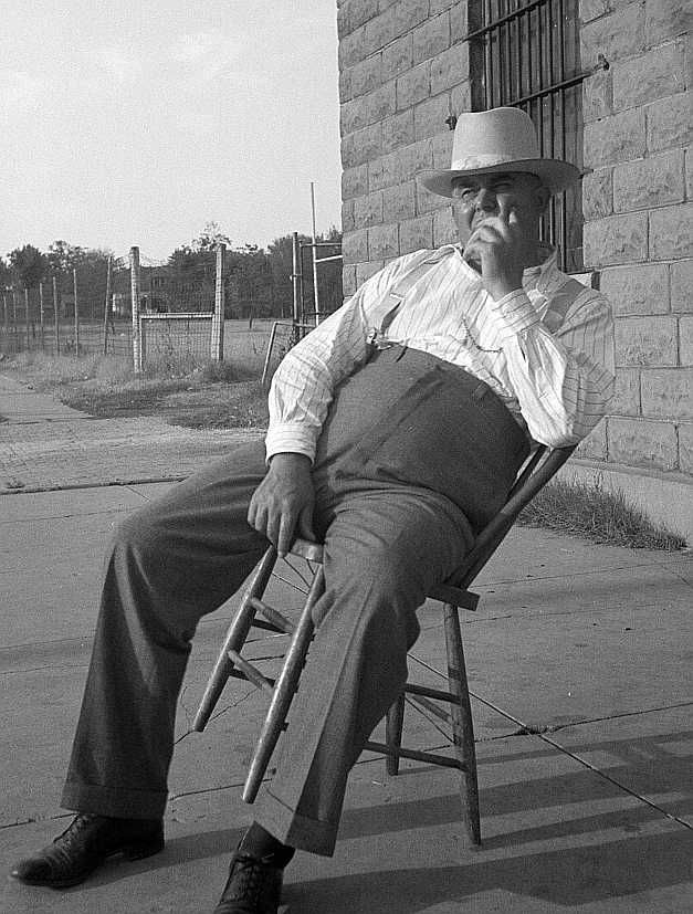 The sheriff of McAlester, Oklahoma, sitting in front of the jail. -- He has been sheriff for thirty years   Photo: Dorothea Lange